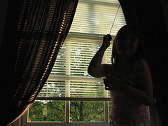 woman closing blinds and curtains